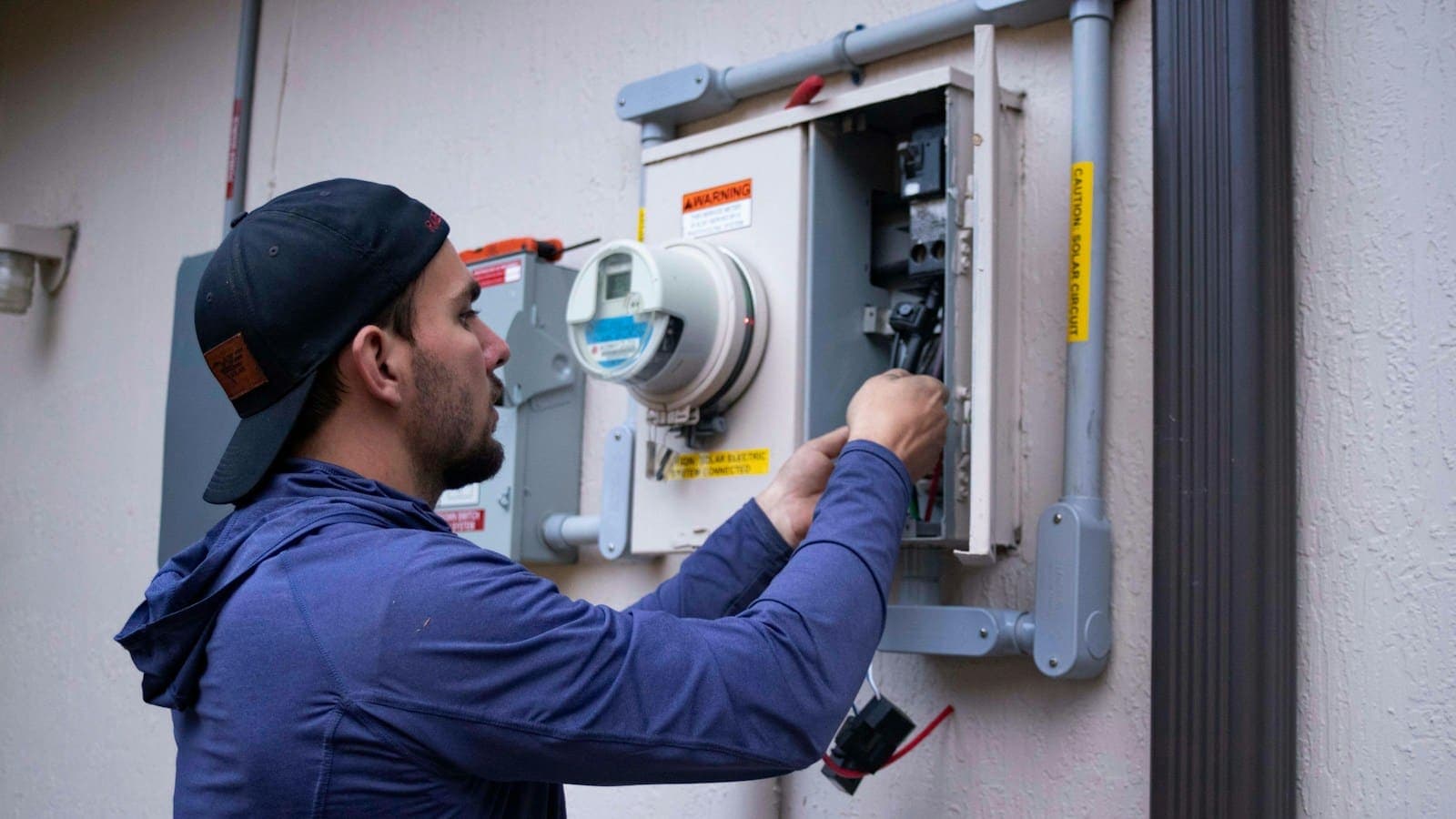 A technician servicing an electrical board at a home